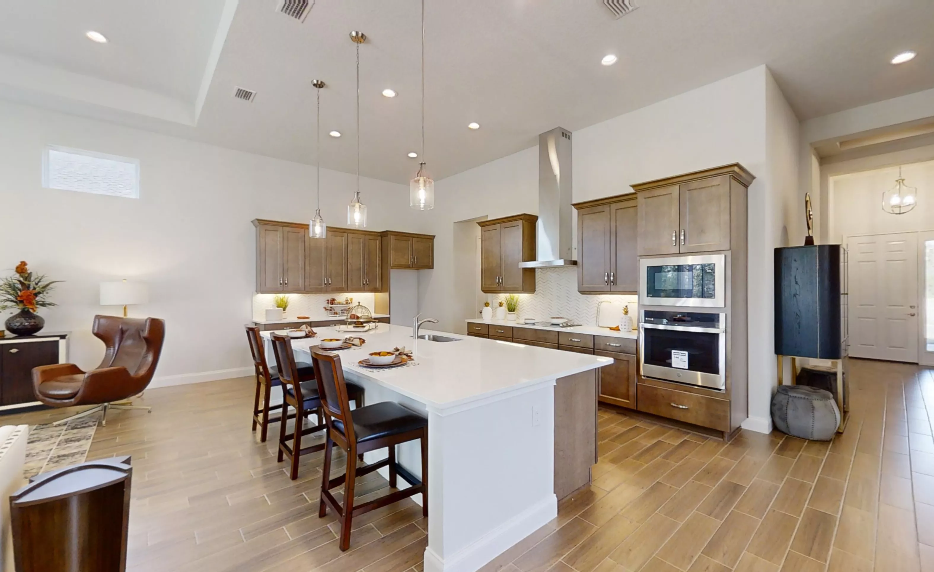 Kitchen in the Charlotte plan featuring wood cabinets, white countertops, an island with bar seating, and tile floors.