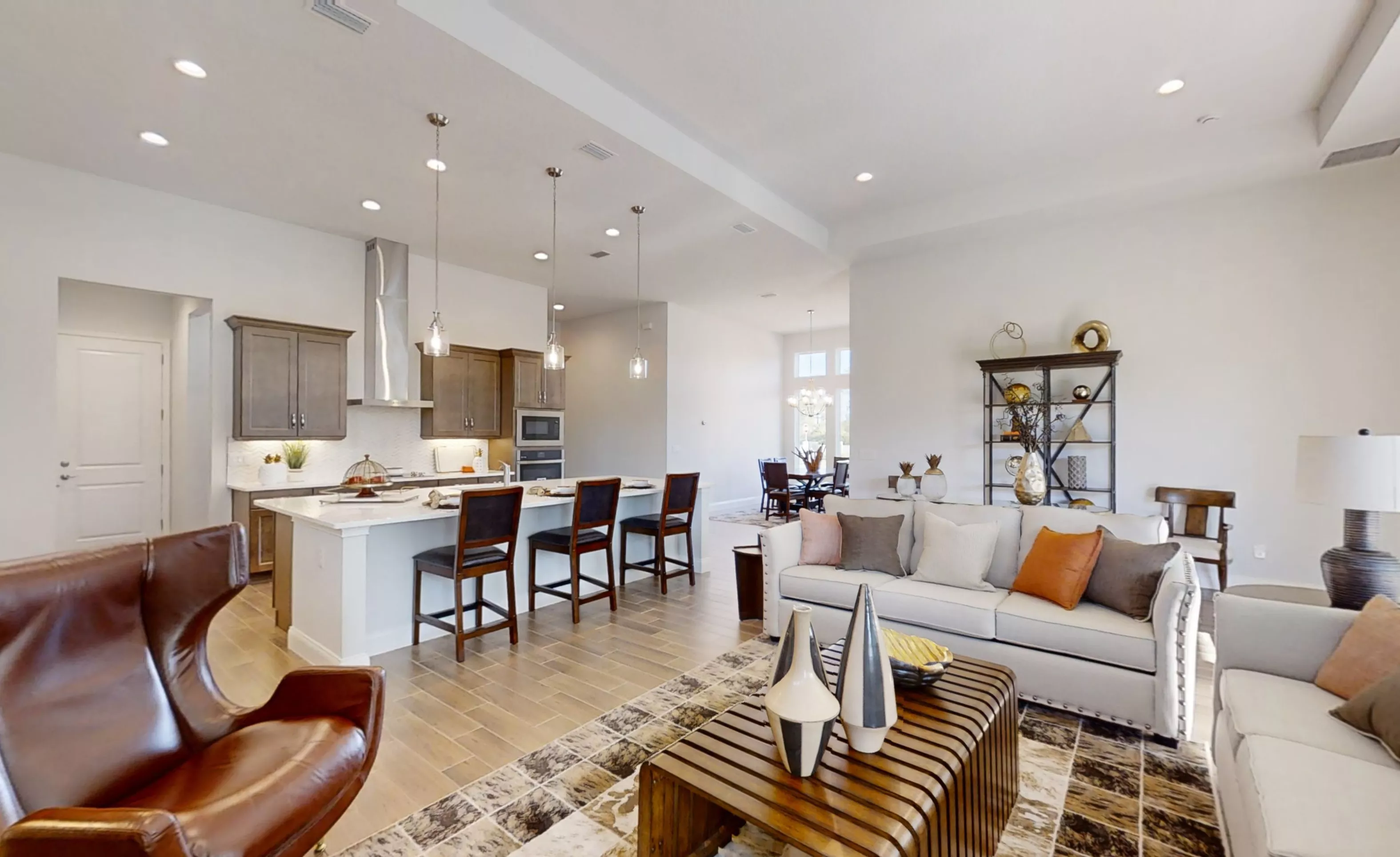 Open-concept living room and kitchen in the Charlotte plan, featuring a central island with bar seating and light flooring.