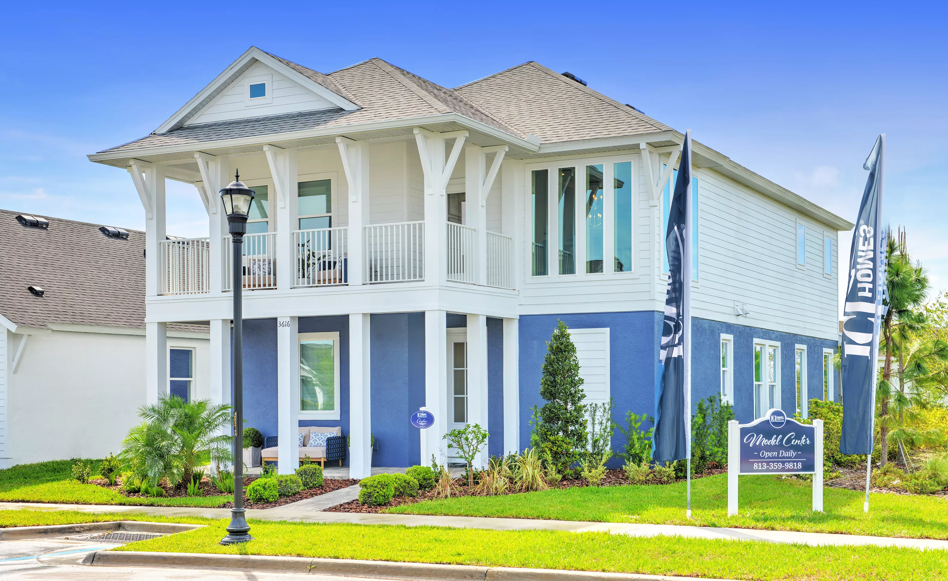 Front exterior of the two-story Azalea model home in Persimmon Park, featuring blue and white siding and a wrap-around porch.