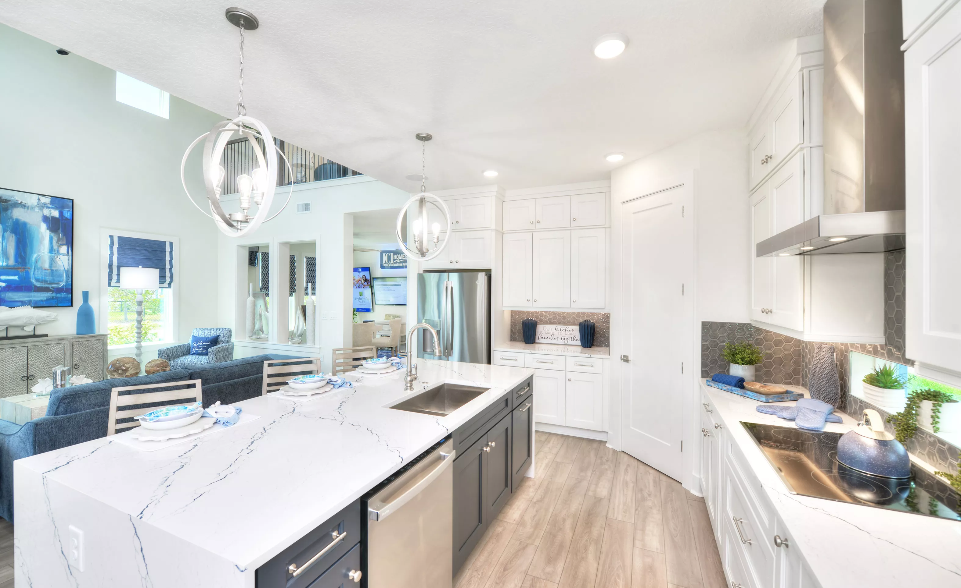 Azalea plan kitchen with white and dark cabinetry, quartz island, stainless steel appliances, and hexagonal backsplash.