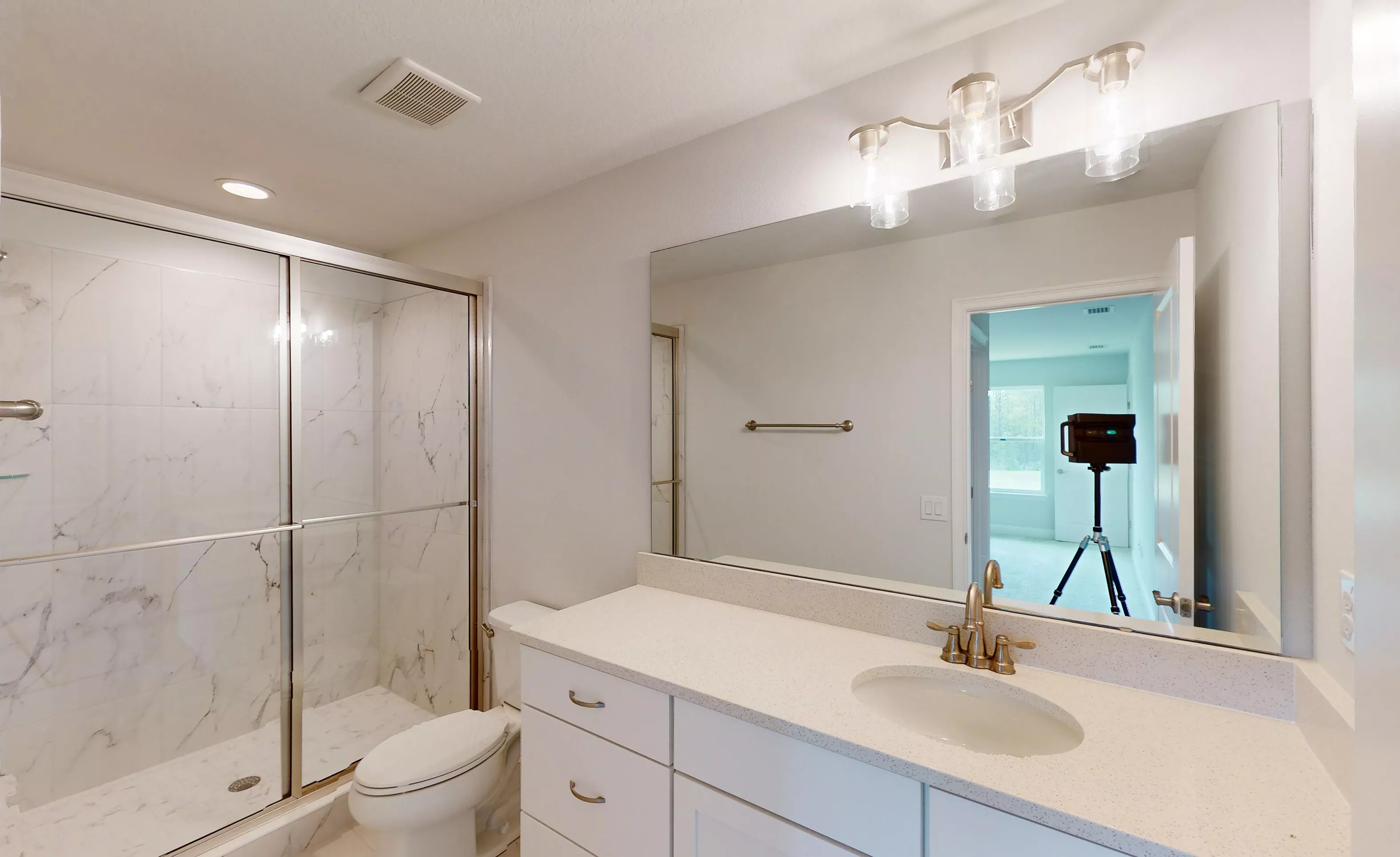 Secondary bathroom featuring a walk-in shower with marble-look tile, white vanity cabinet, light countertop, and wall mirror.