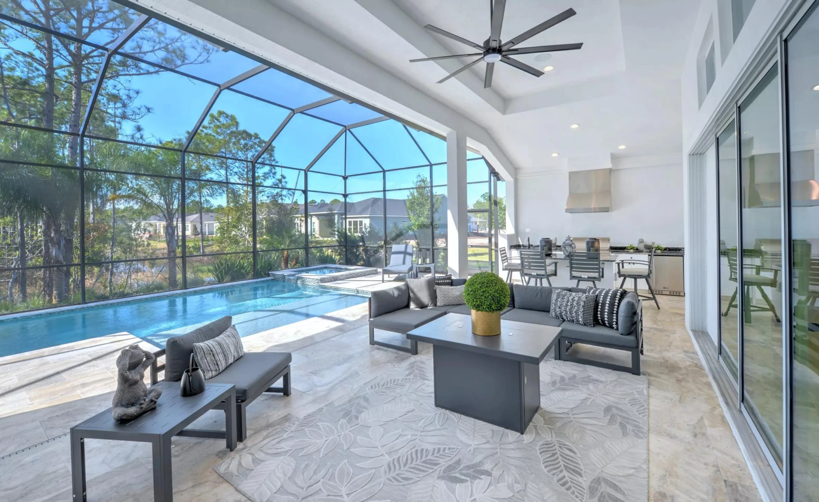 Covered lanai in Woodhaven featuring a seating area, outdoor kitchen, and screened-in pool with spa.
