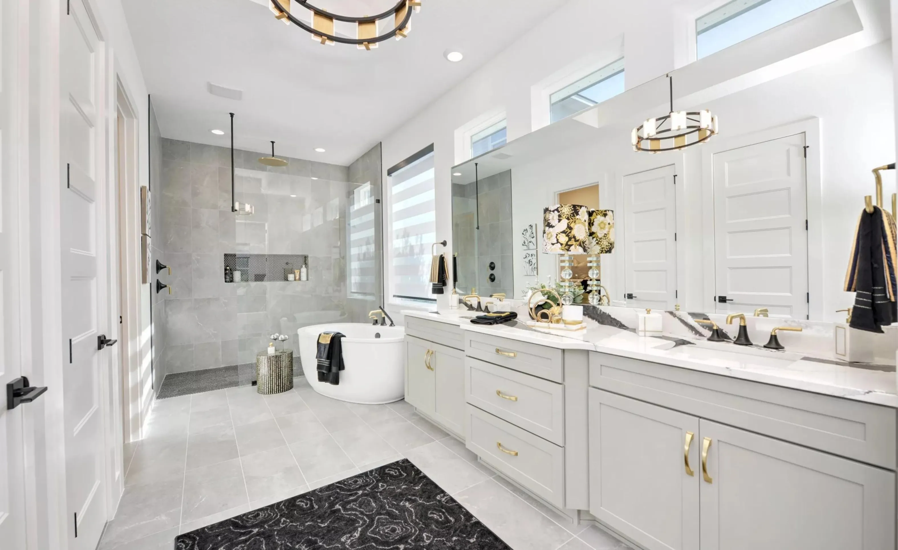 Modern primary bathroom in Woodhaven with a grey vanity, white marble countertops, a freestanding tub, and a glass shower.