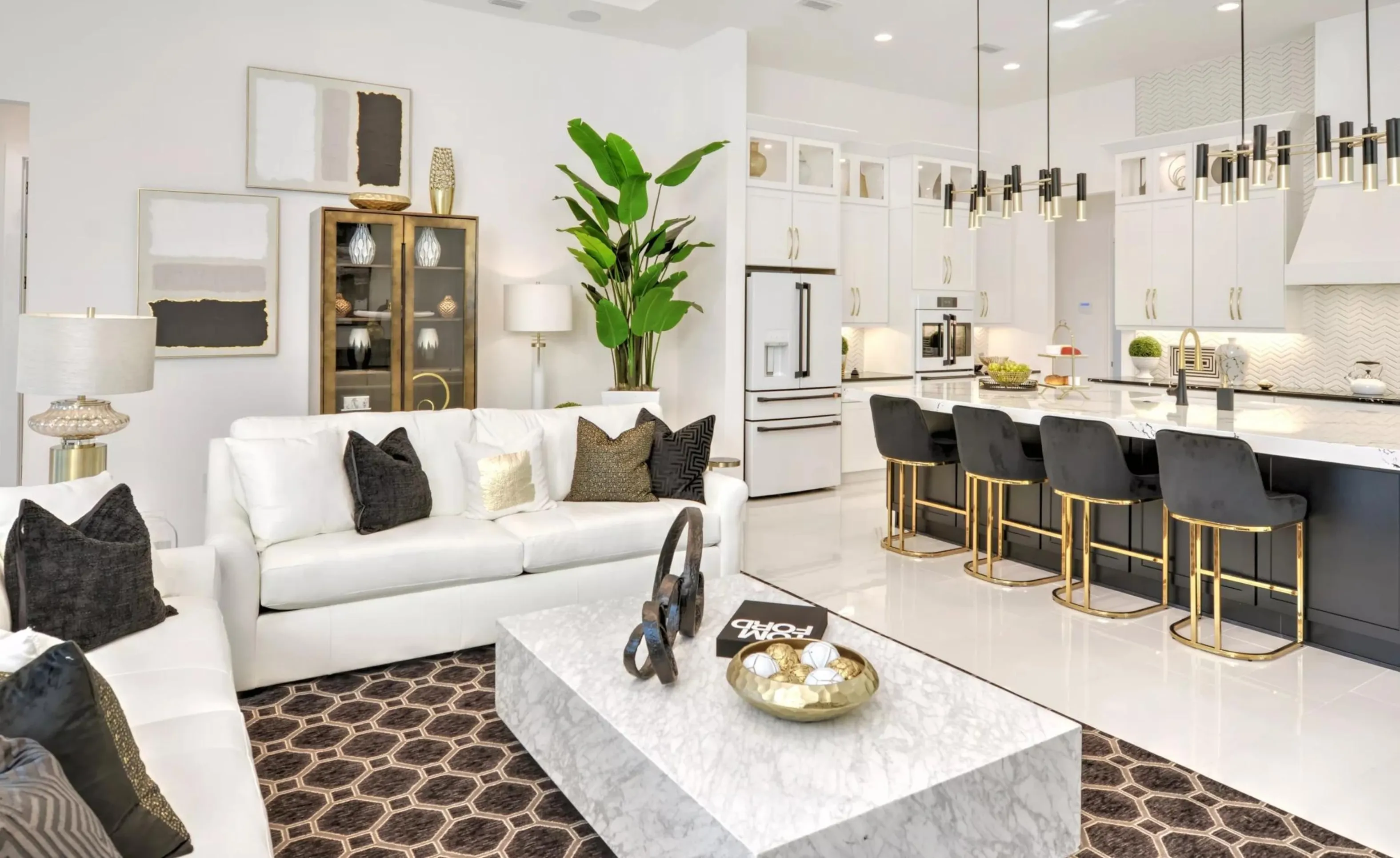 Open-concept living room and kitchen in Woodhaven featuring white sofas, a marble coffee table, and a black-and-white kitchen.