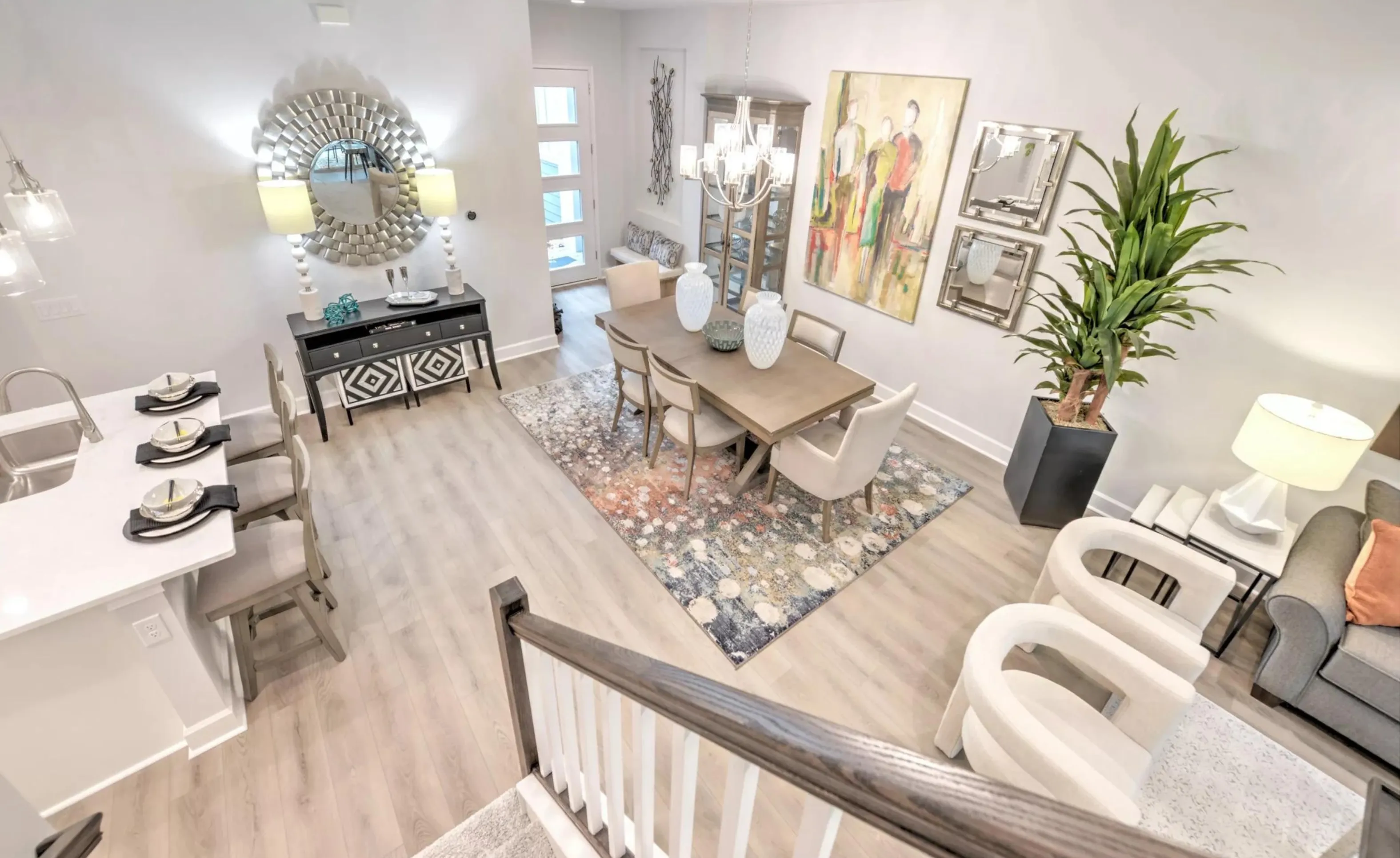 High-angle view of a dining room in Woodhaven featuring a rectangular table, upholstered chairs, area rug, and wall decor.