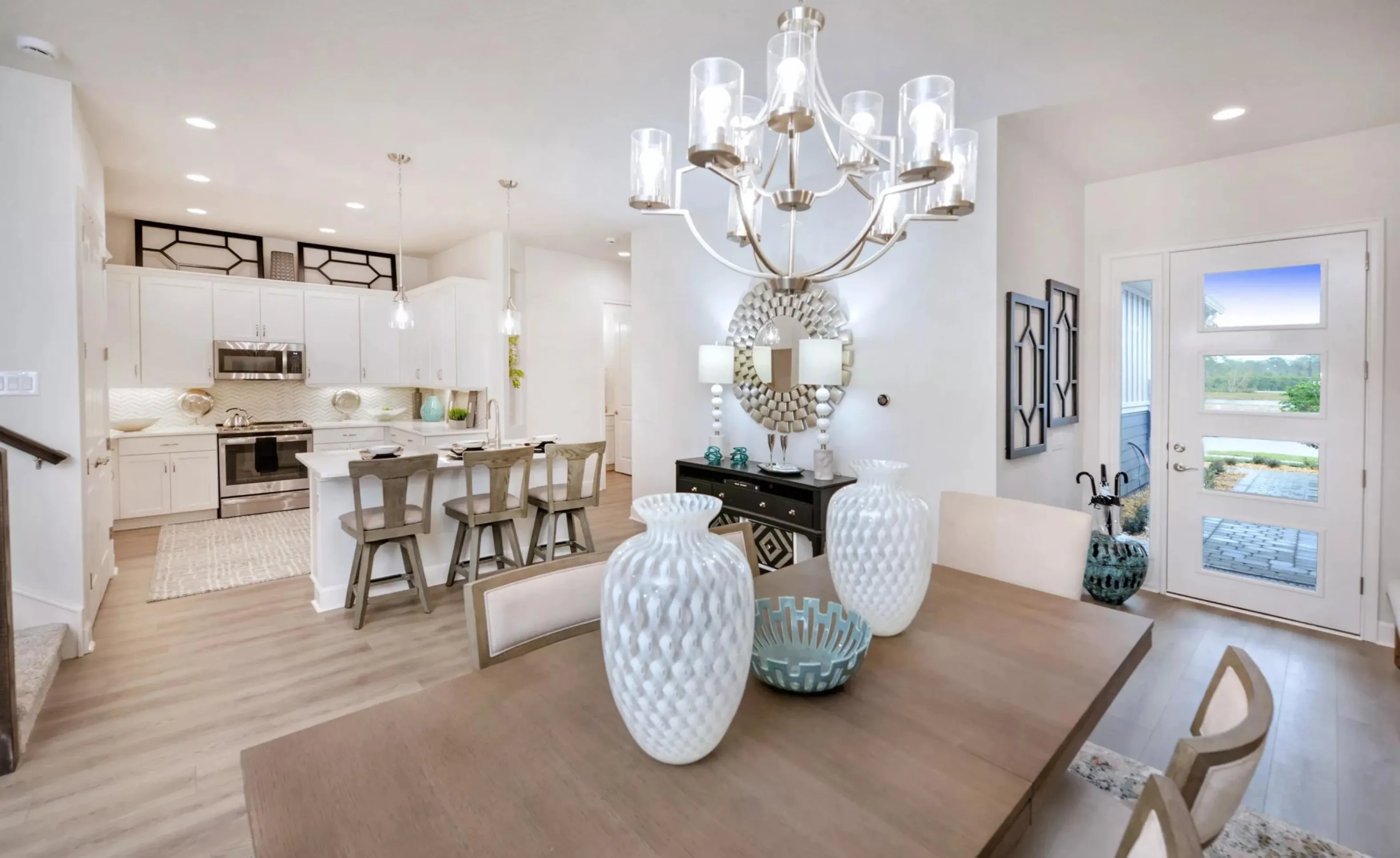 Open-concept kitchen and dining area in Woodhaven with a large wooden dining table, a kitchen island, and white cabinetry.