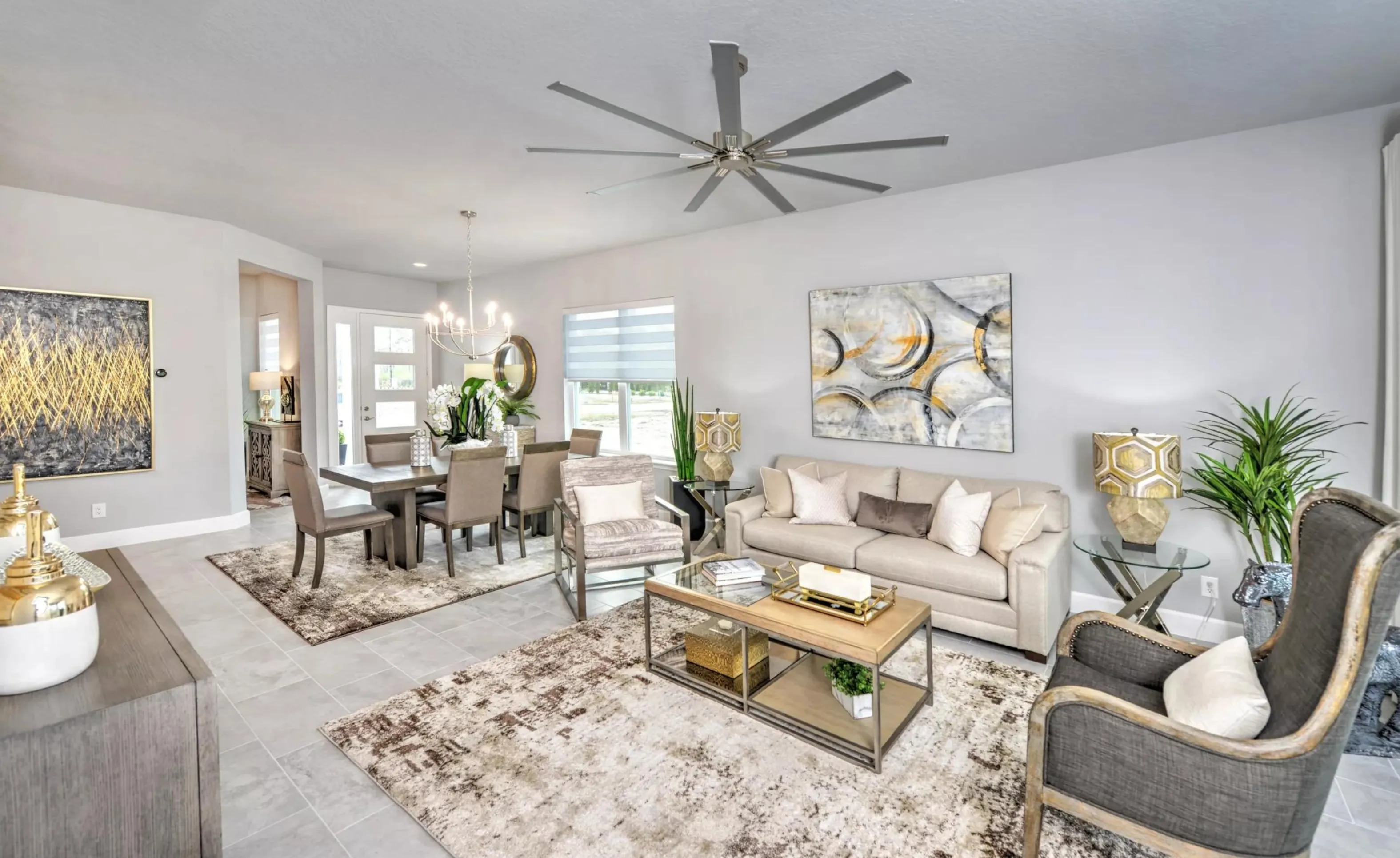 Open-concept living and dining area in Woodhaven with neutral furniture, tile floors, and a large ceiling fan.
