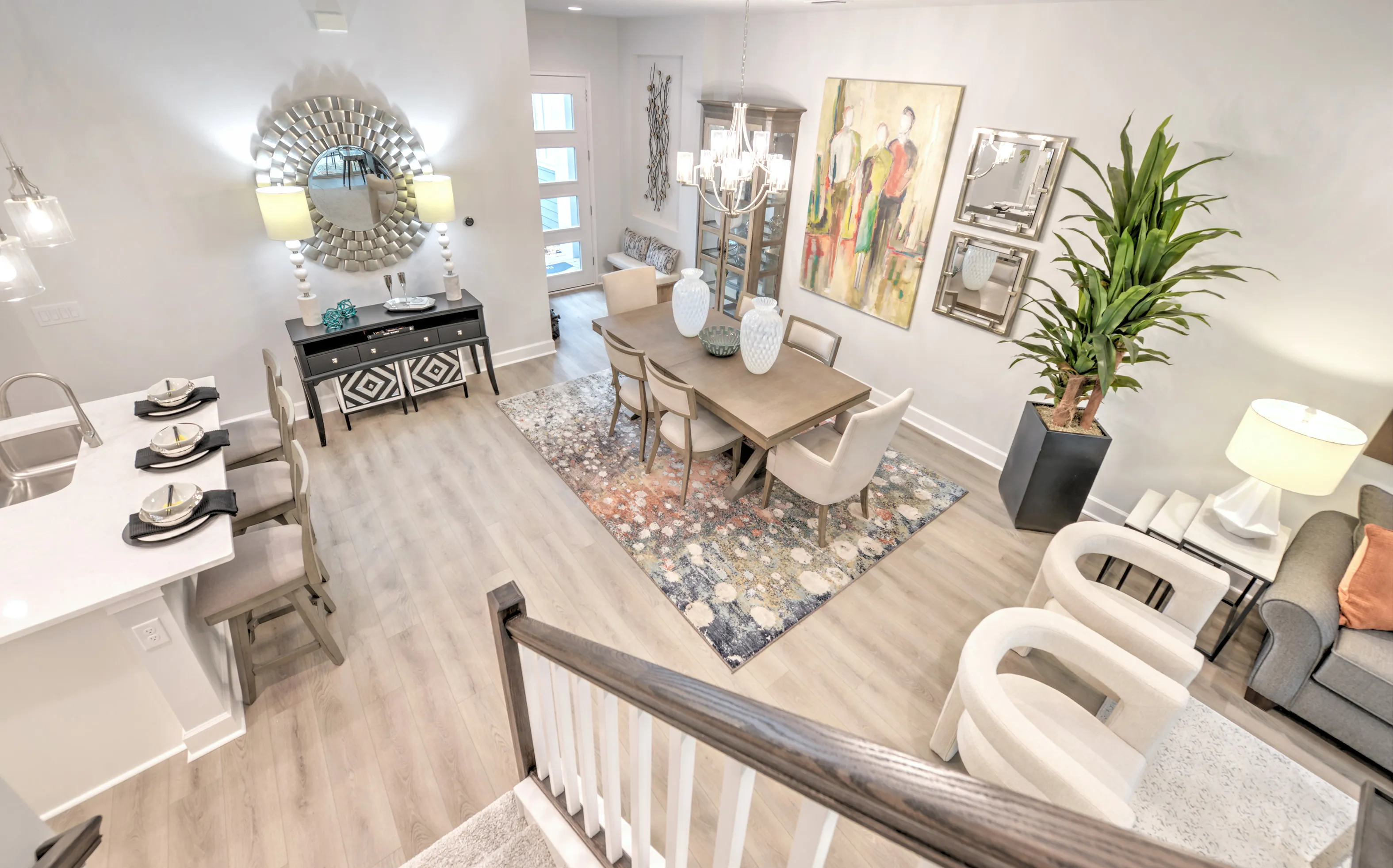 High-angle view of a Woodhaven Townhomes dining area with wood-look flooring, a chandelier, and a kitchen island.