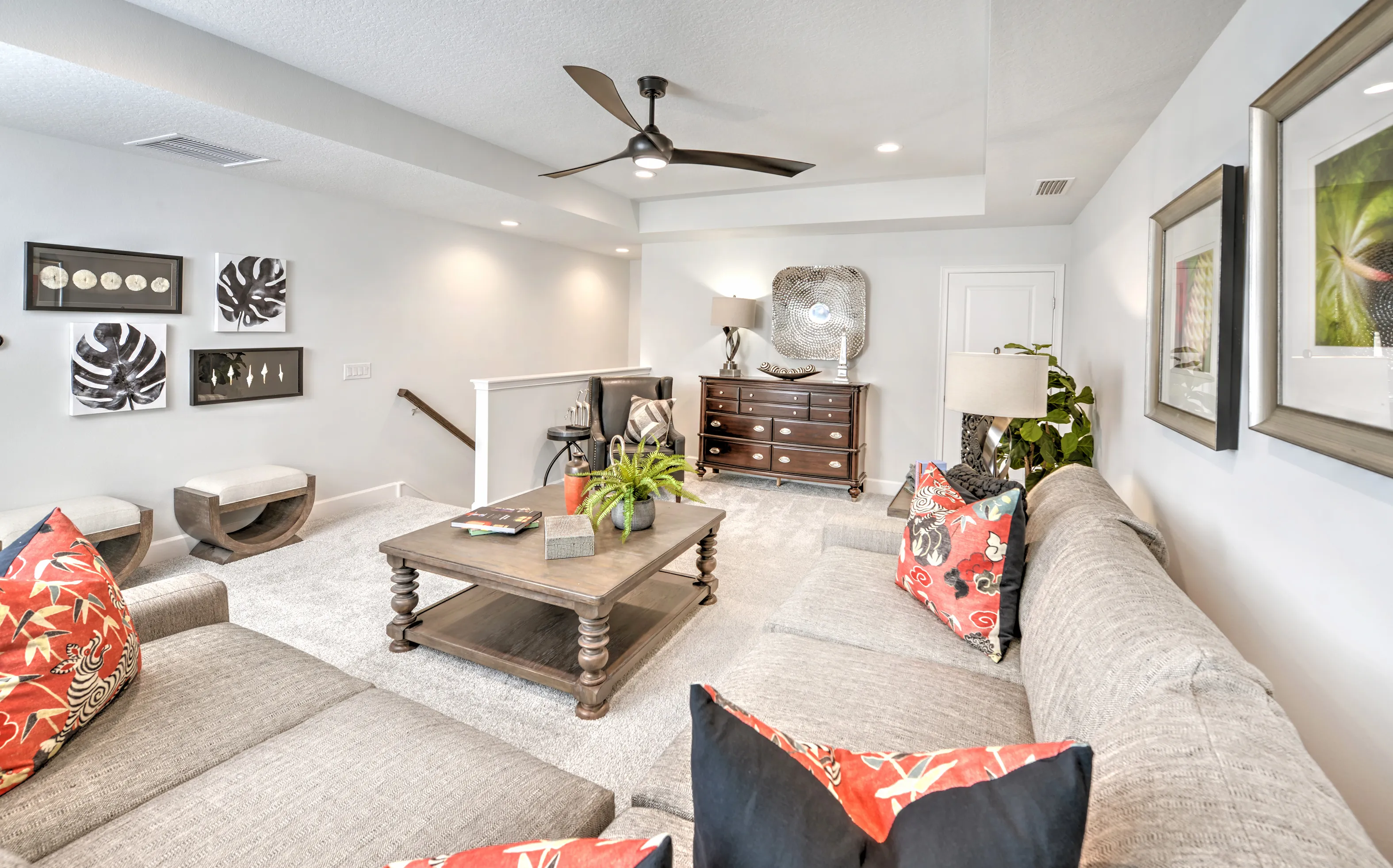 Living area in Woodhaven Townhomes featuring gray sectional seating, a dark wood coffee table, and carpeted floors.