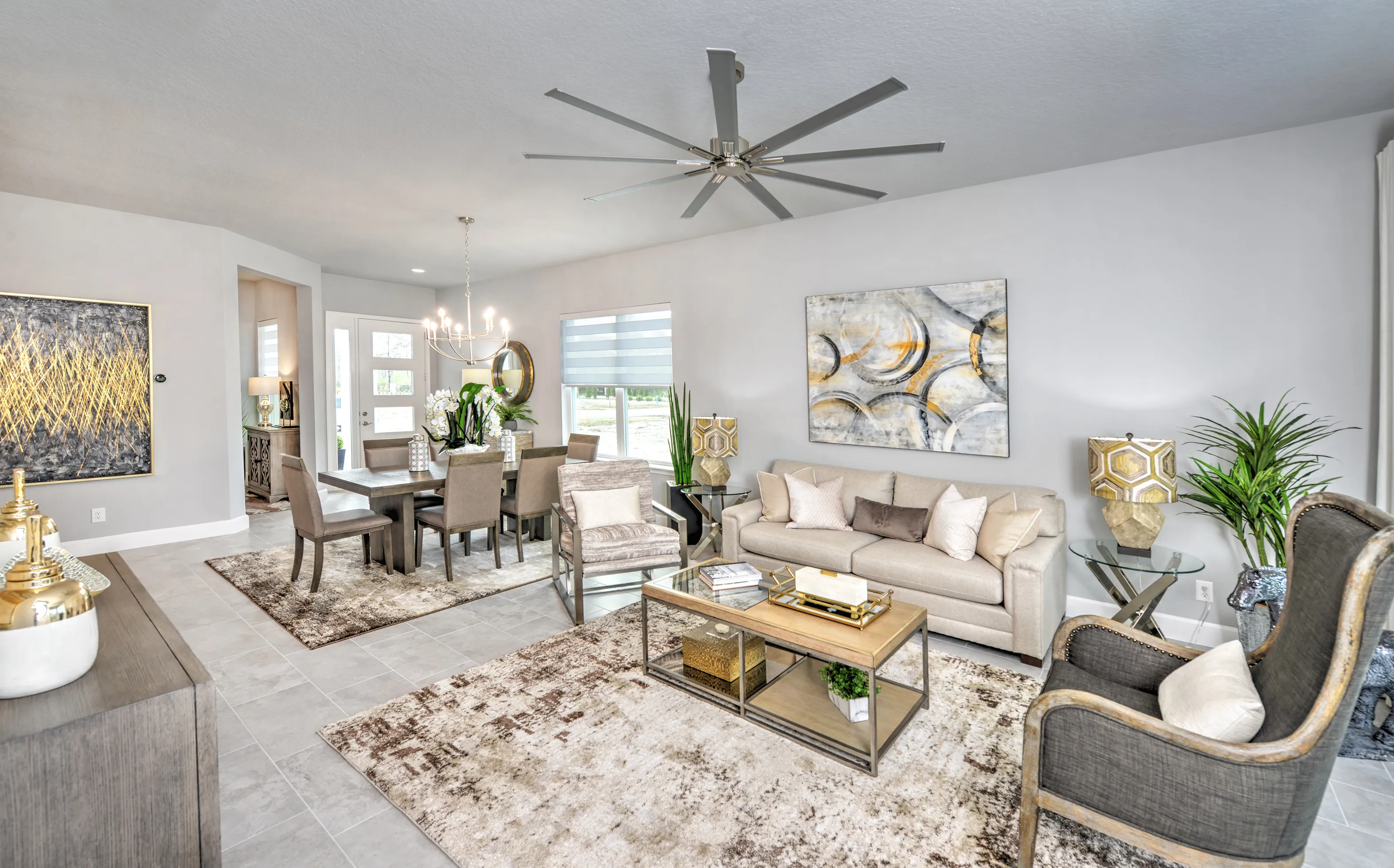 Open-concept living and dining area in Woodhaven Townhomes featuring light tile floors, a large ceiling fan, and decor.