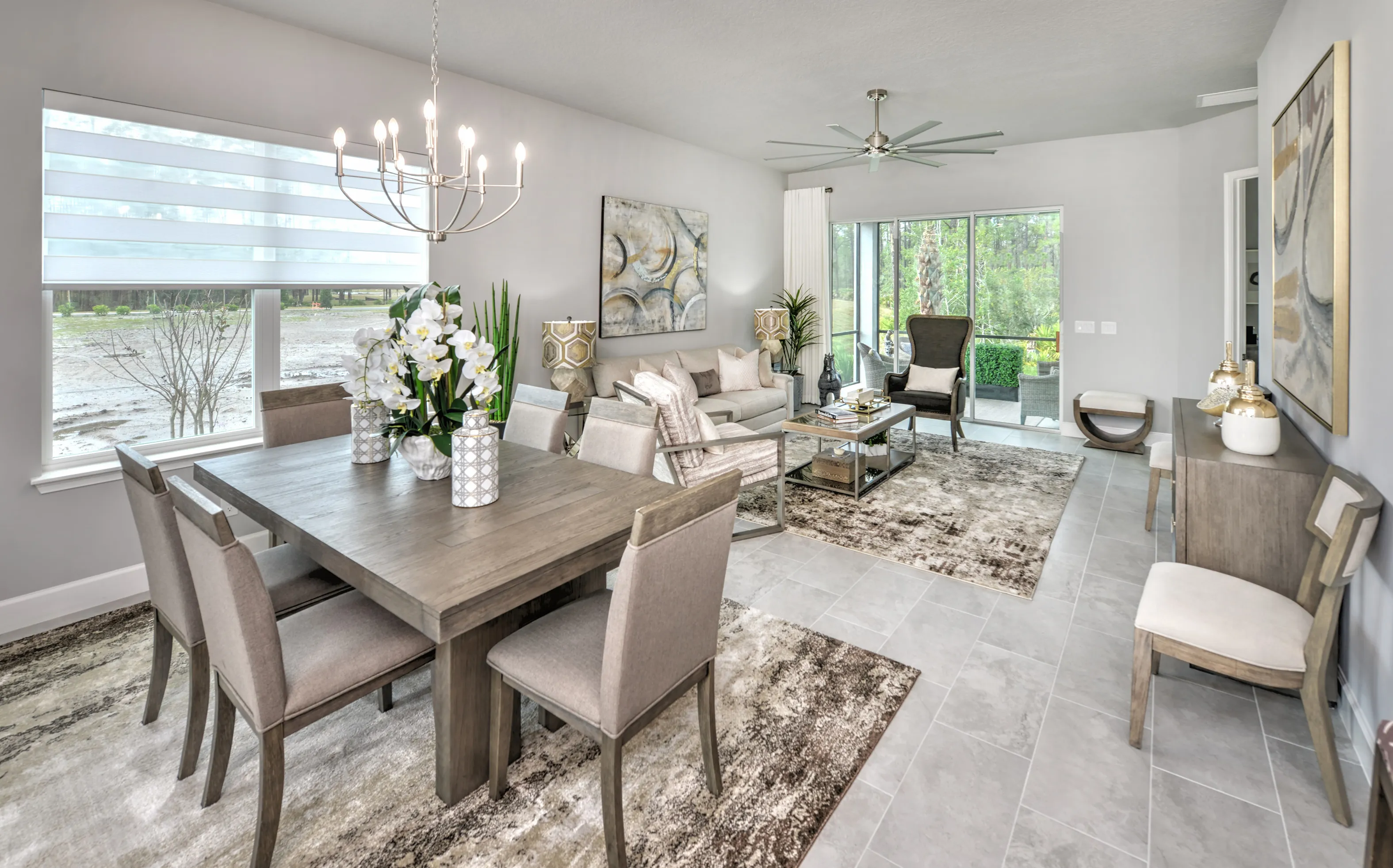 Open-concept dining and living area in a Woodhaven Townhome with light gray tile floors and large windows.