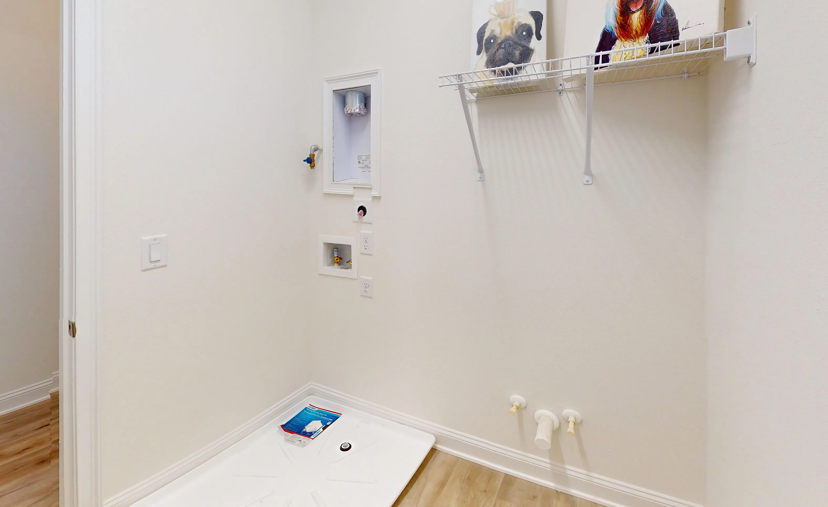Laundry room in the Bartram floor plan featuring a white floor pan, wall connections, and a wire shelving unit.