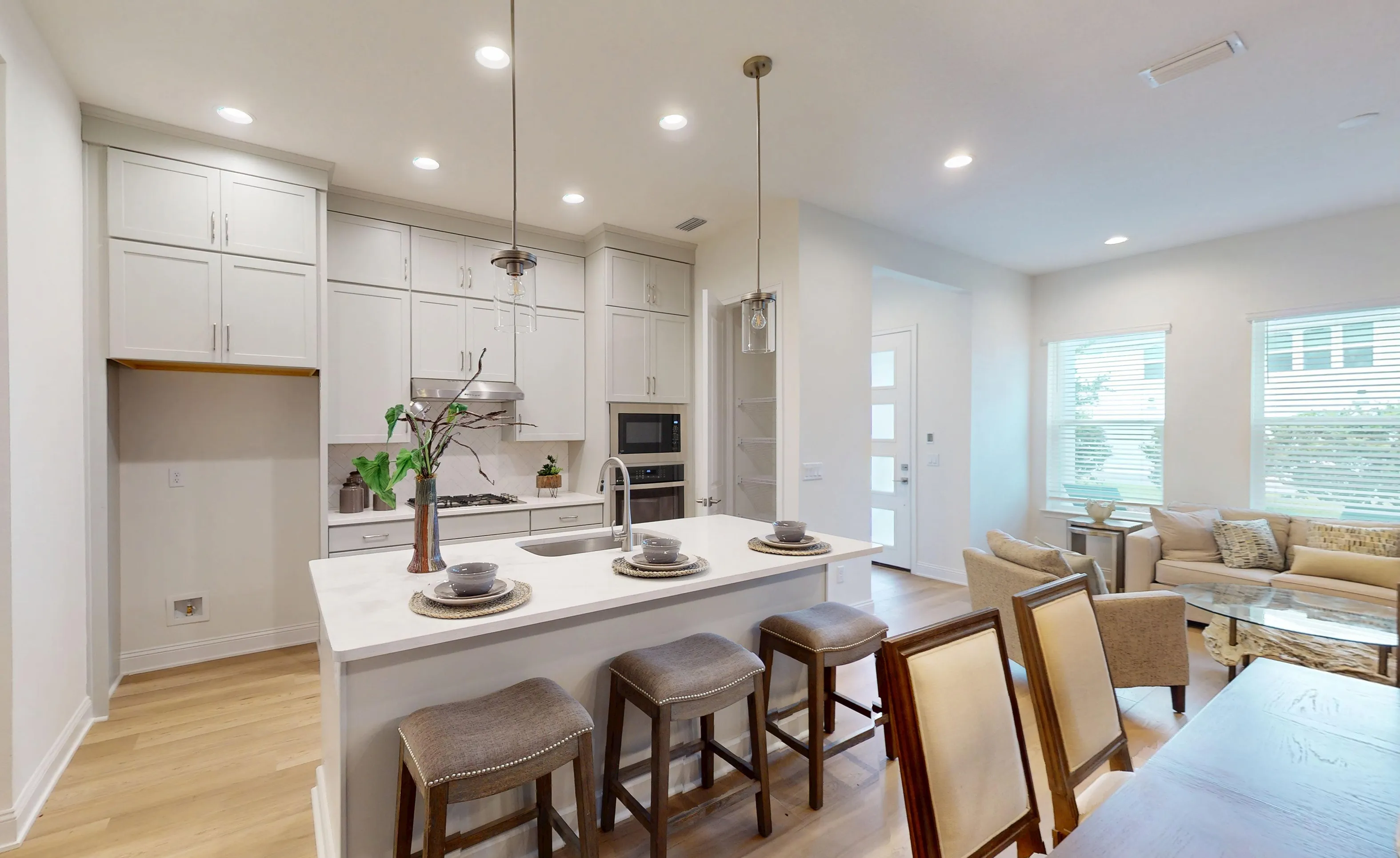 Modern kitchen in the Castillo plan featuring white cabinetry, a central island with bar seating, and recessed lighting.