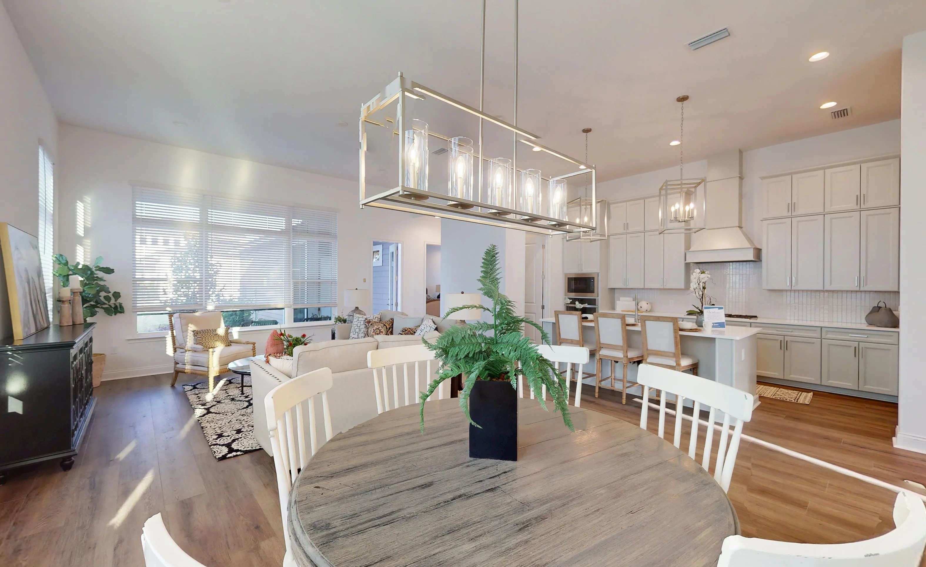 Open-concept kitchen and dining area in Kona plan at Oakmont featuring grey cabinets, kitchen island, and dining table.