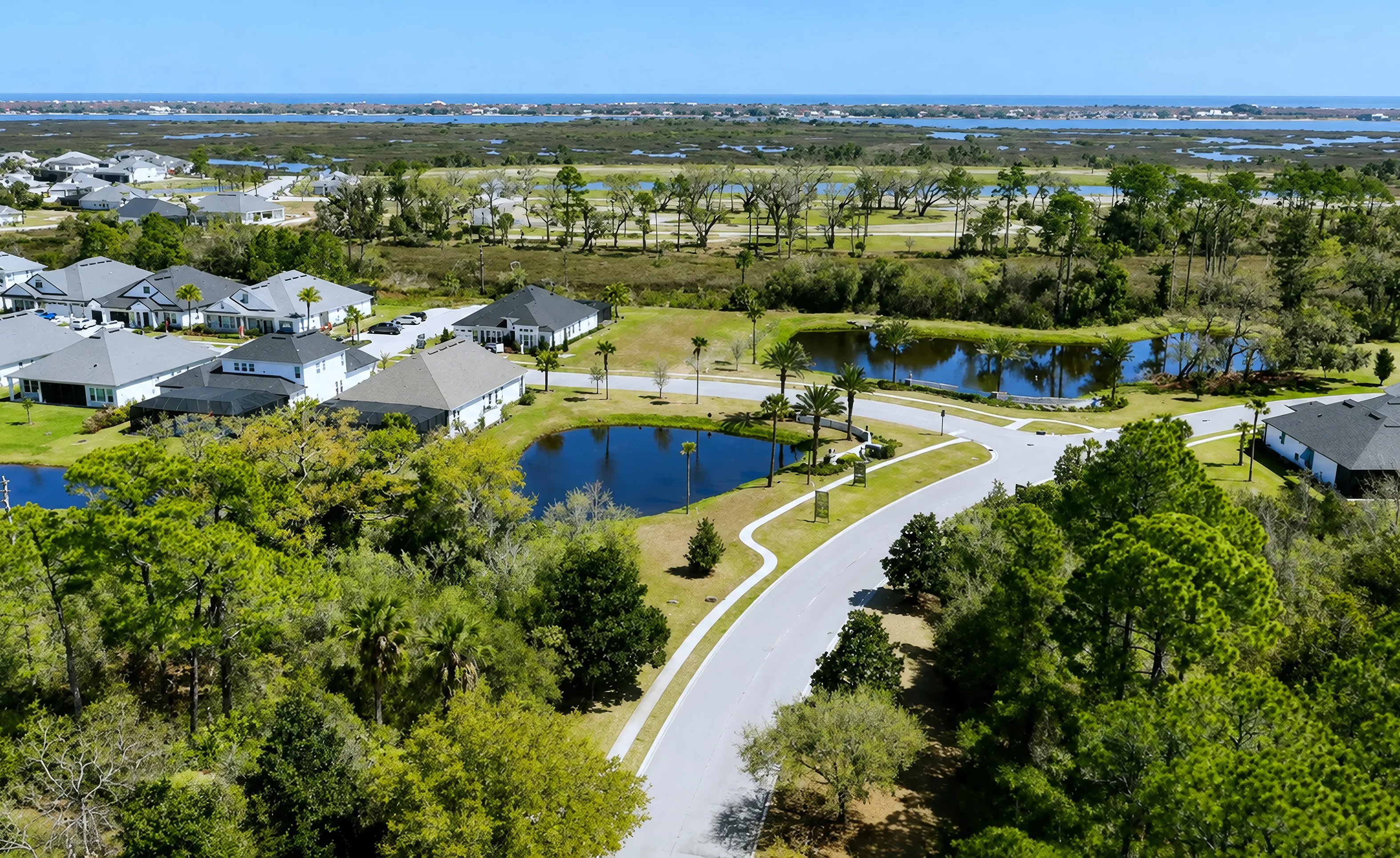 Aerial view of Madeira at St Augustine showing residential streets, ponds, green spaces, and houses near a marshy landscape.