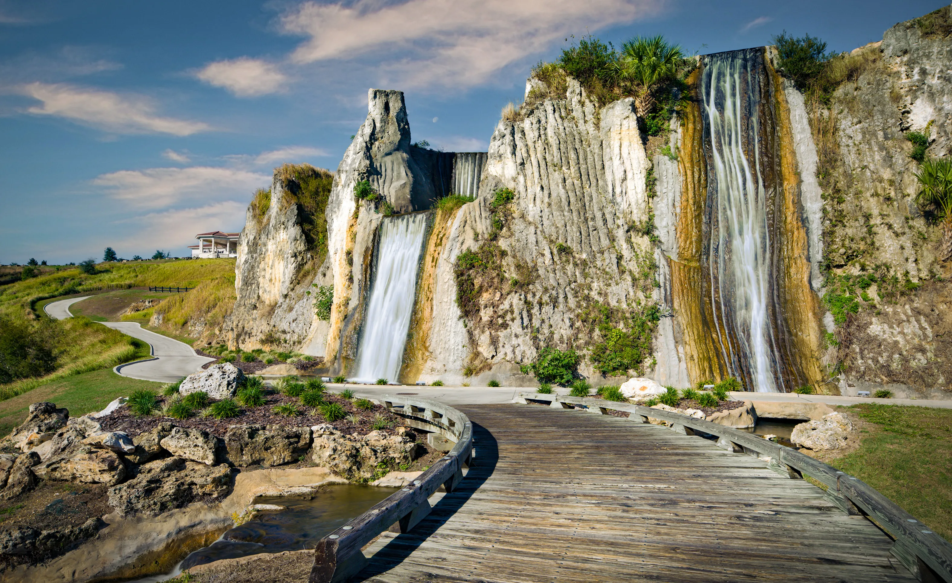 Wooden bridge leading to large multi-tiered rock waterfalls at the IronCrest community.
