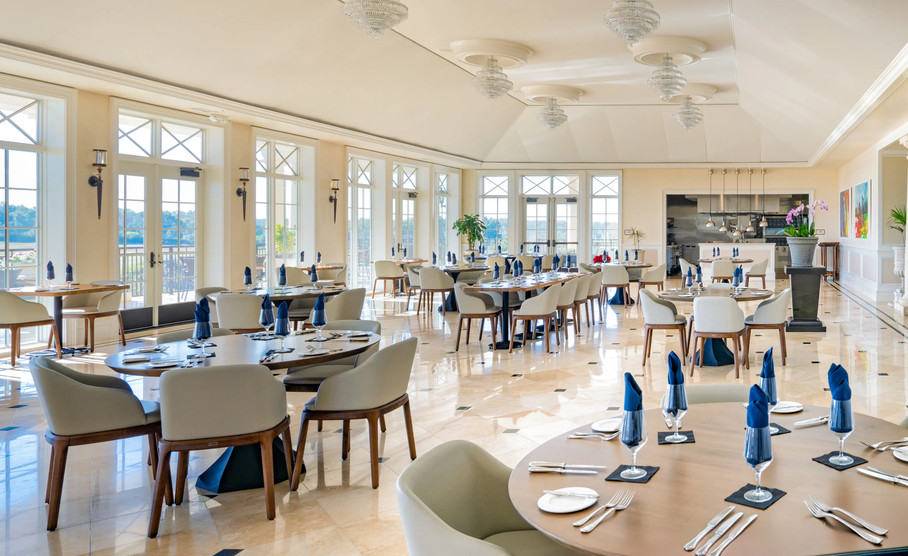 Spacious IronCrest community dining room with circular tables, modern chairs, tile floors, and large windows.
