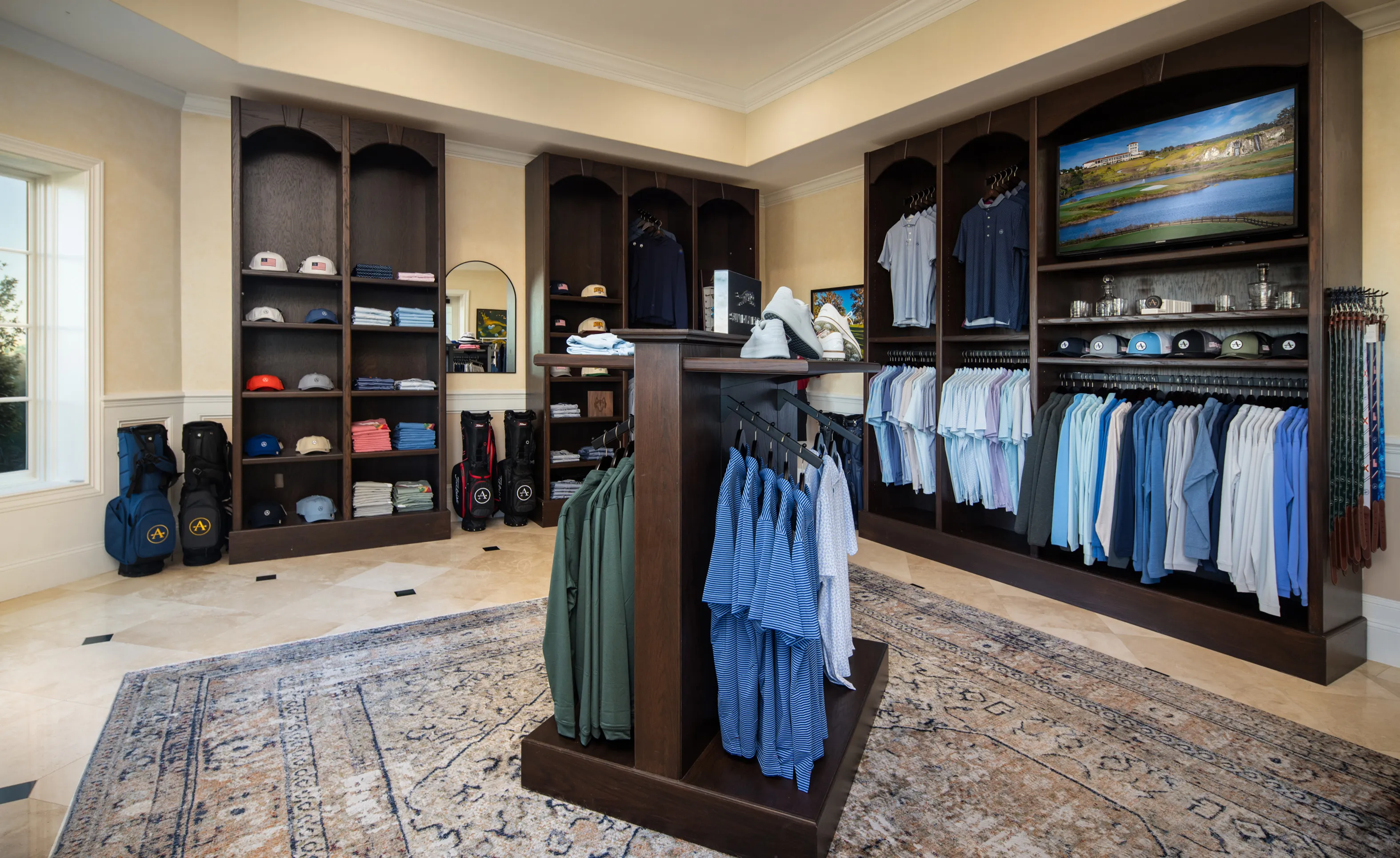 Golf shop at IronCrest with dark wood shelving, clothing racks, tiled floors, and a patterned area rug.