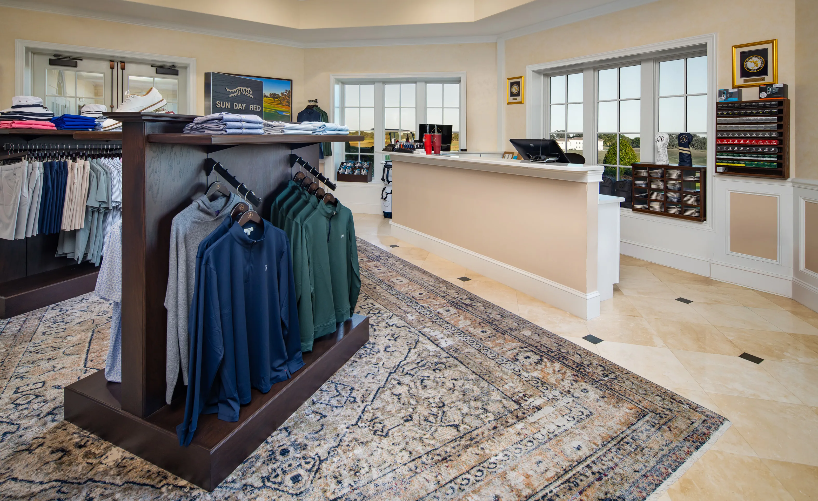 Interior of the IronCrest golf pro shop featuring a clothing display rack, a service counter, and tile floors with a rug.