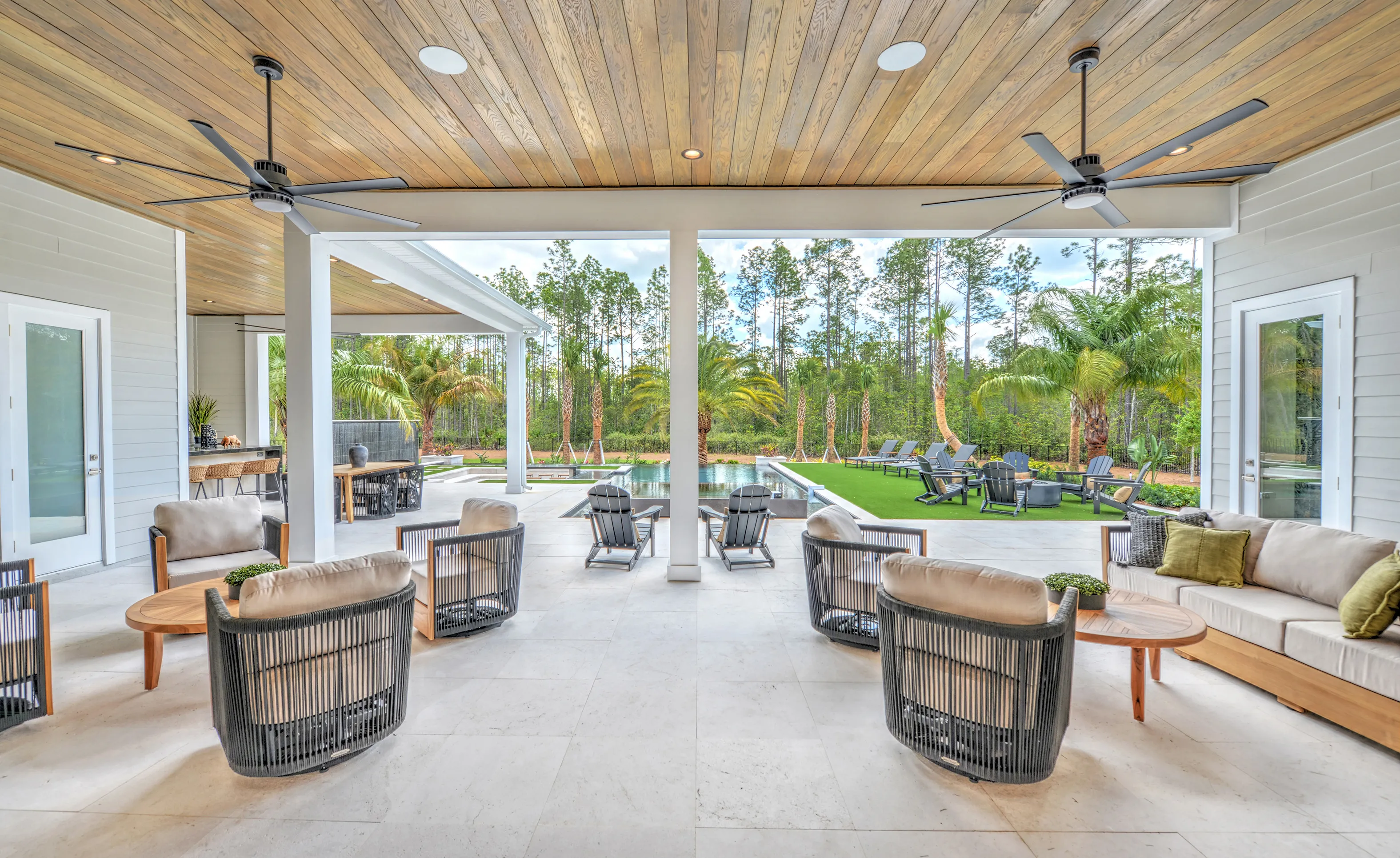 Covered outdoor living area at Courtney Grove featuring a wood-plank ceiling, tile flooring, and a view of a pool.