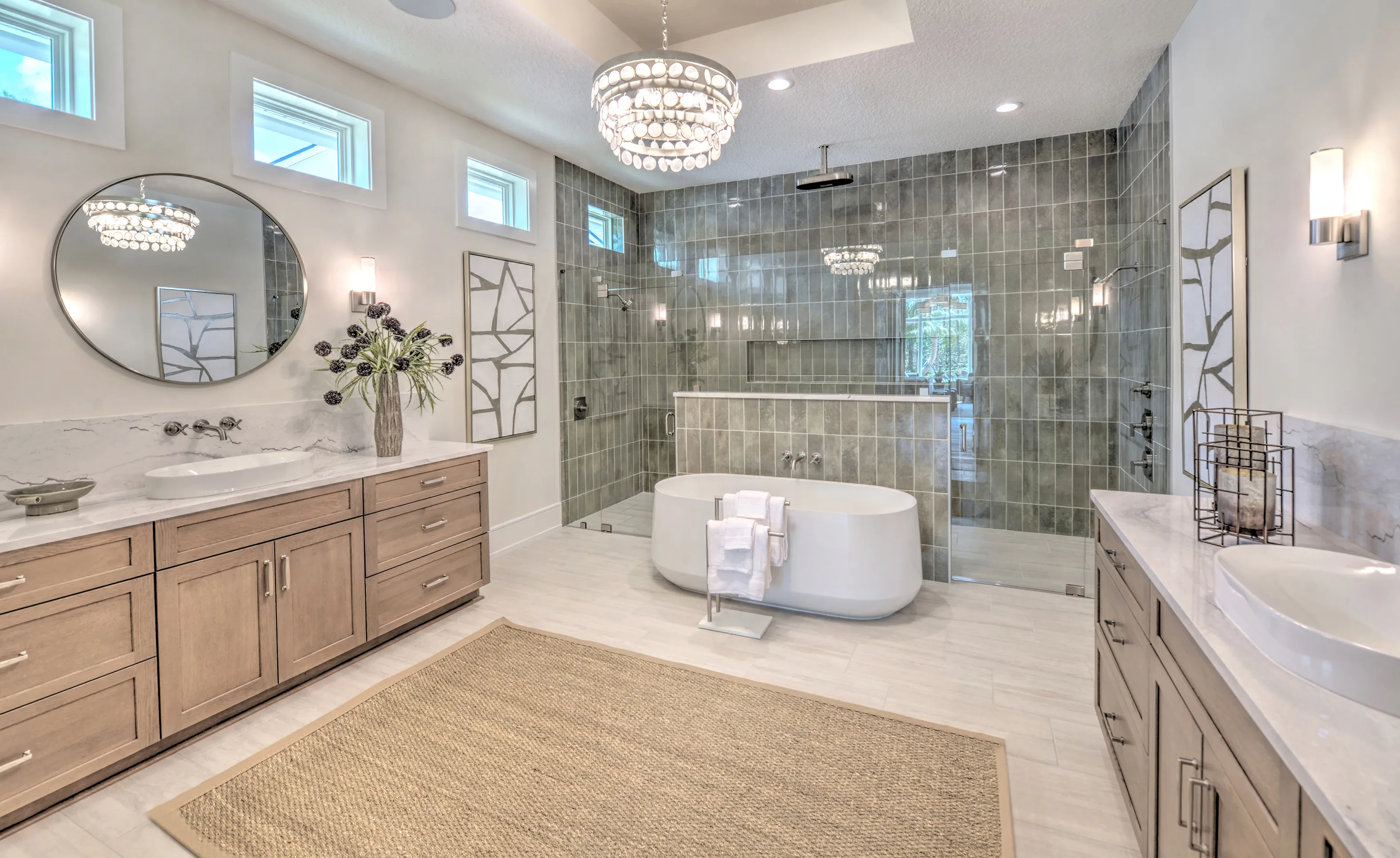 Courtney Grove primary bathroom featuring dual wood vanities, a freestanding tub, and a glass-enclosed gray tiled shower.
