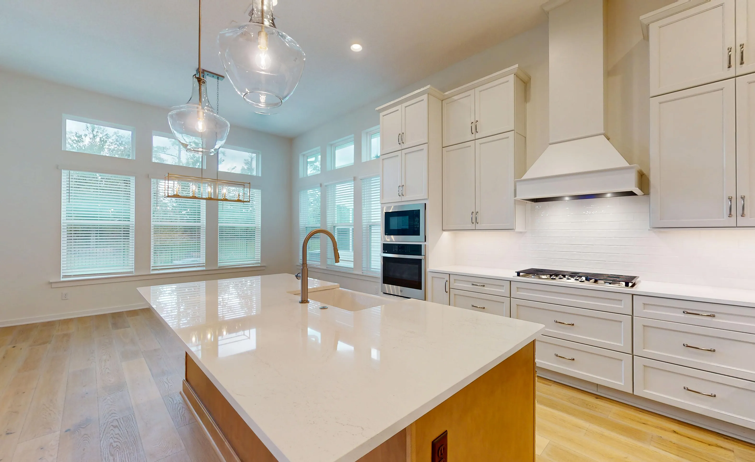 Modern kitchen in the Palos Verdes plan featuring a light-wood island, white cabinetry, quartz countertops, and large windows.