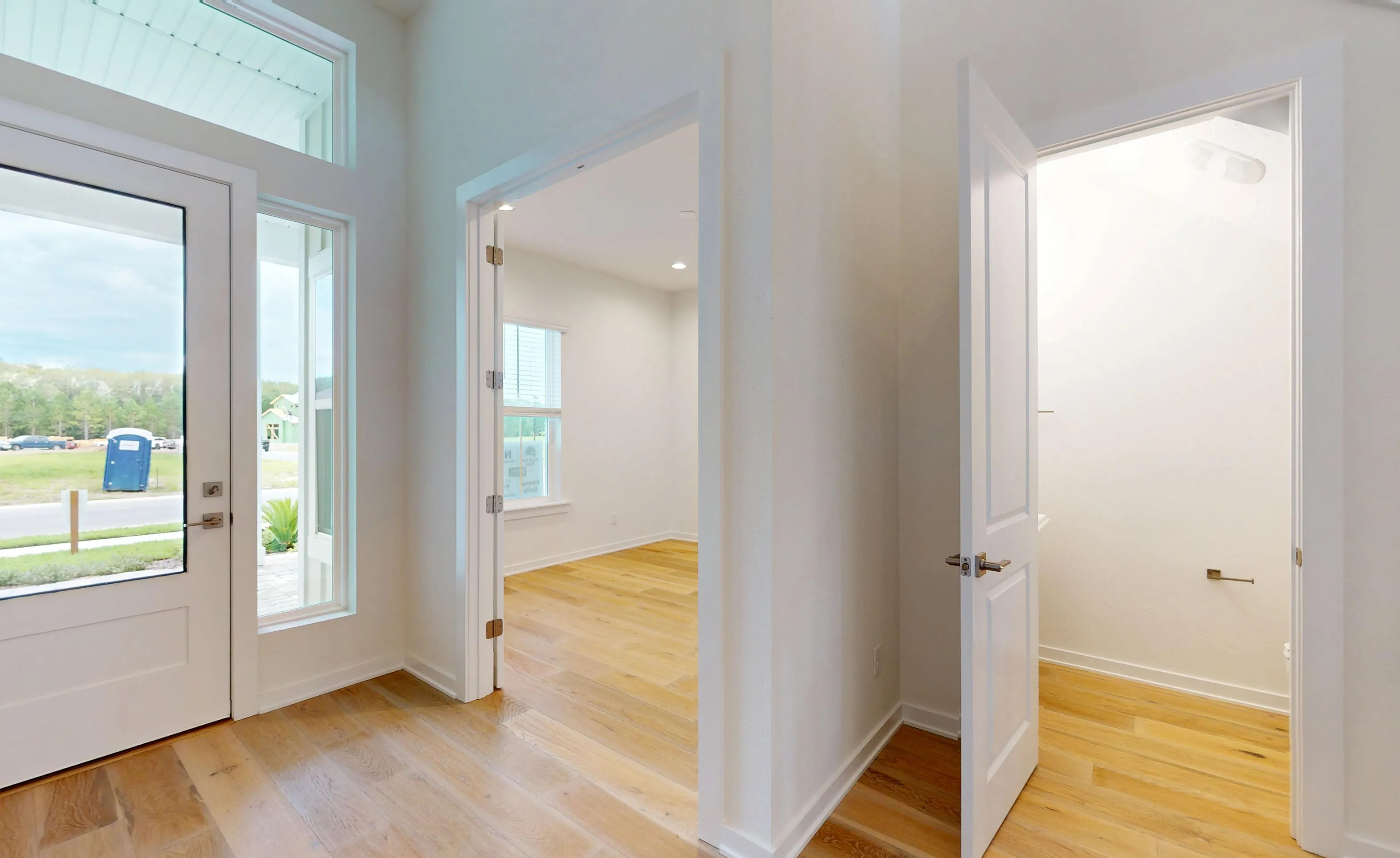 Foyer of the Palos Verdes plan with light wood flooring, a glass-paneled front door, and doorways leading to adjacent rooms.