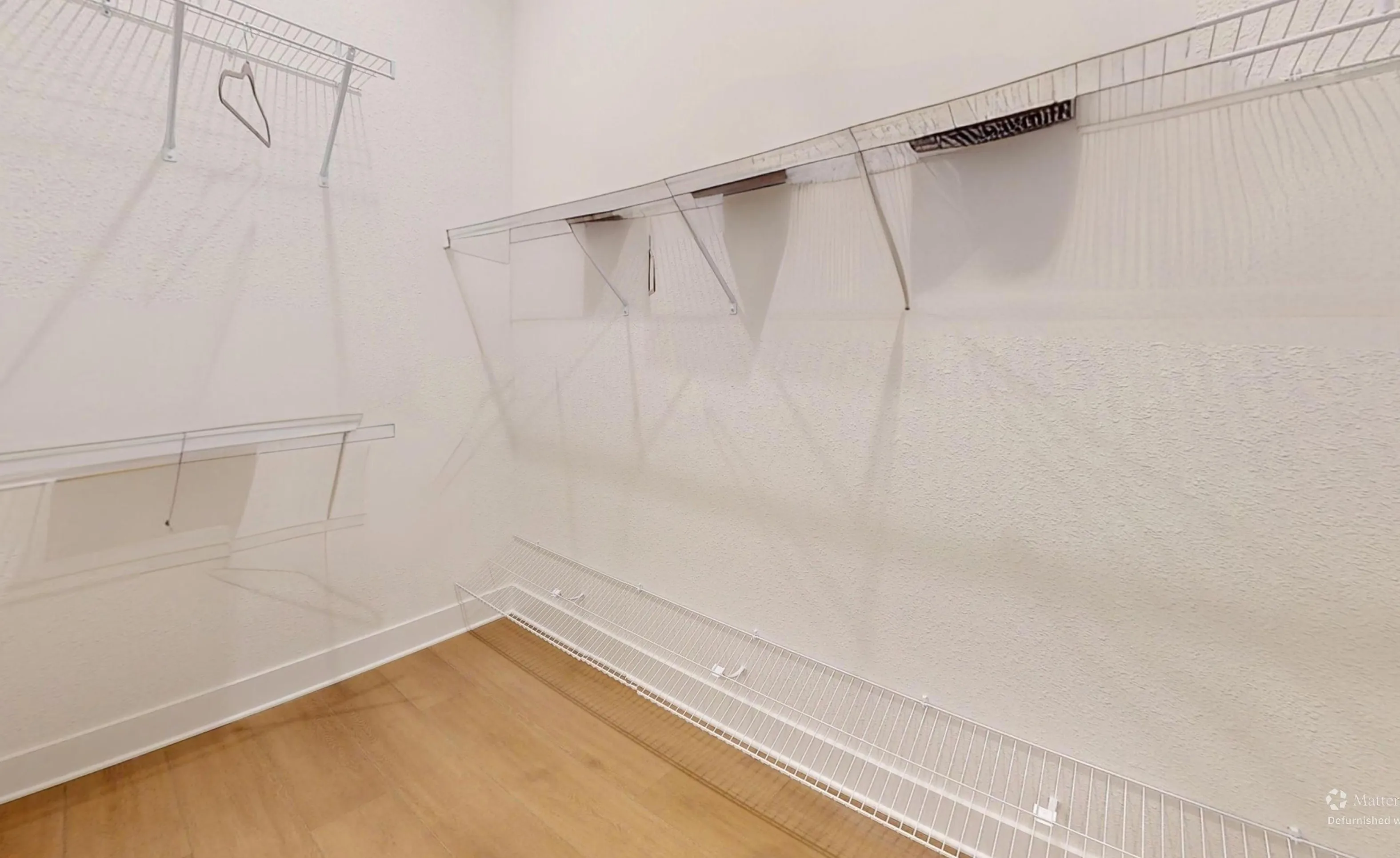 Walk-in closet in the Braddock plan at Seven Pines with white wire shelving and light wood-tone flooring.
