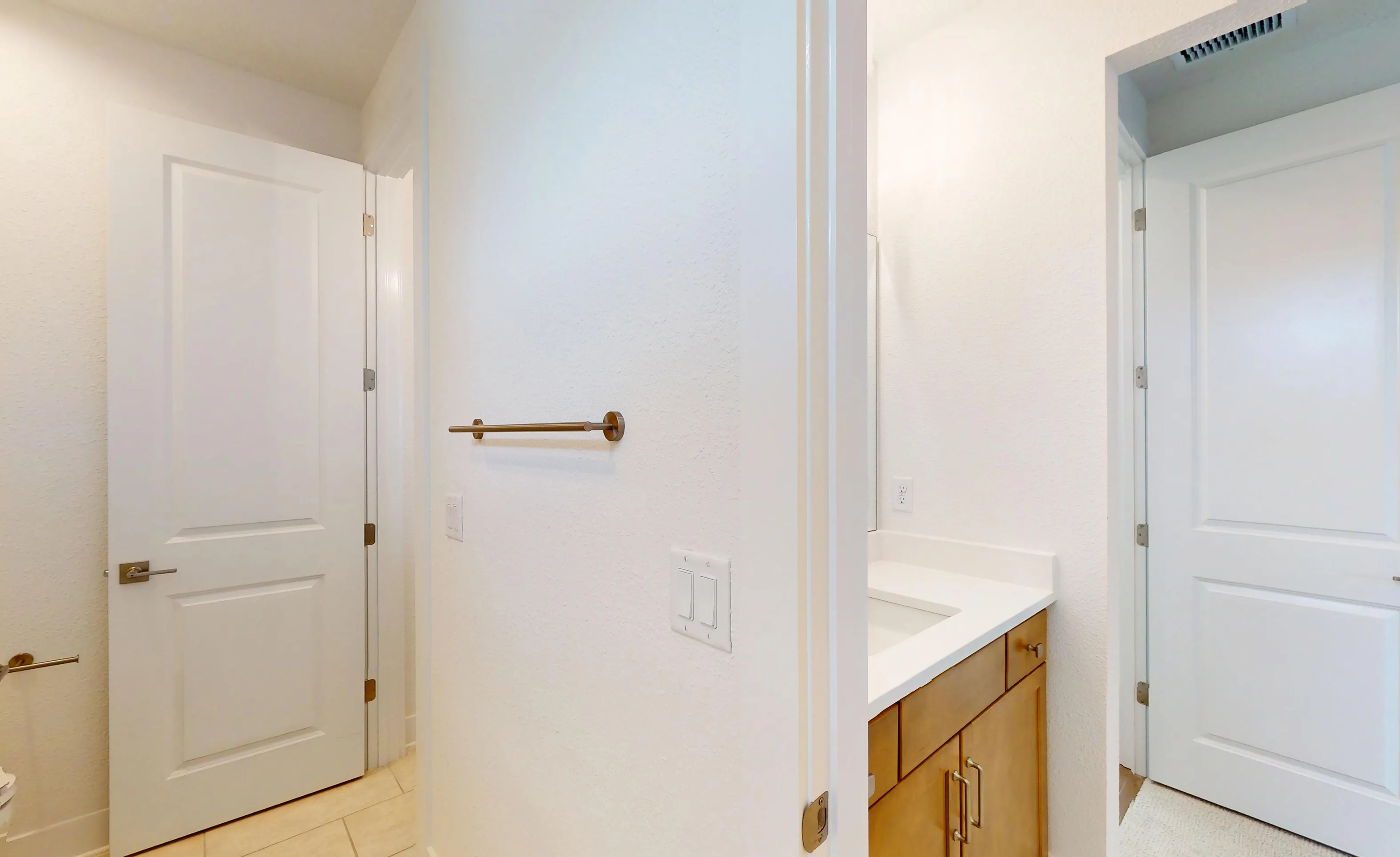 Secondary bath in the Braddock plan at Seven Pines featuring wood vanity cabinets, white countertops, and white doors.