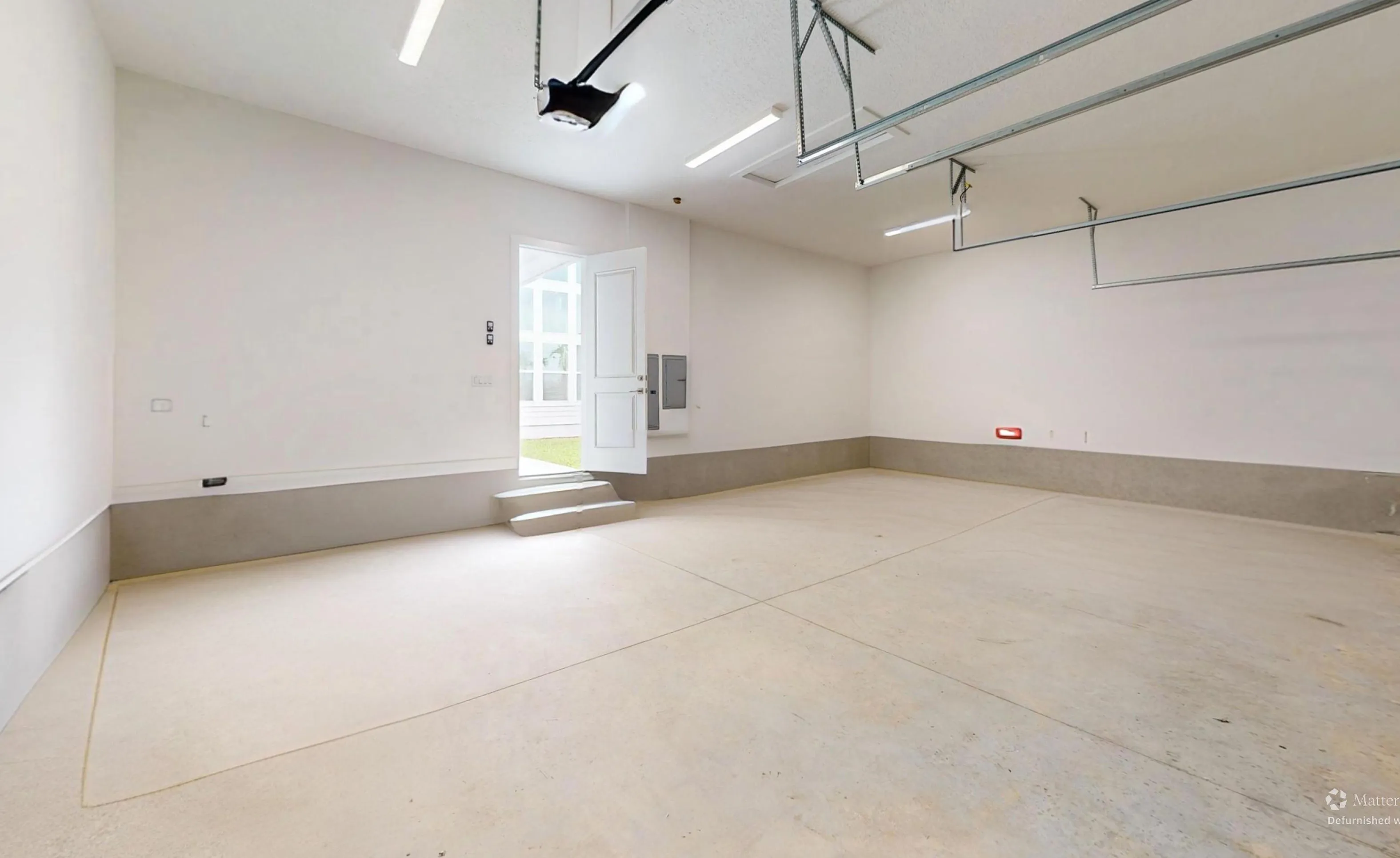 Empty Braddock plan garage in Seven Pines with white walls, a concrete floor, and an exterior door with two steps.